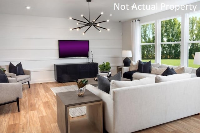 living room with a notable chandelier and light hardwood / wood-style floors