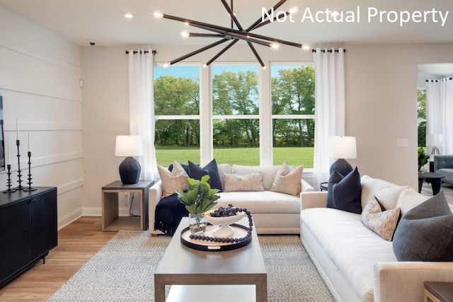 living room featuring light wood-type flooring and a notable chandelier