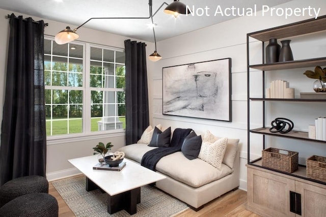 living area with a wealth of natural light and light hardwood / wood-style floors