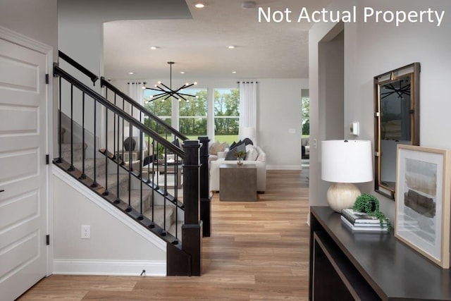 stairs featuring a chandelier and hardwood / wood-style flooring