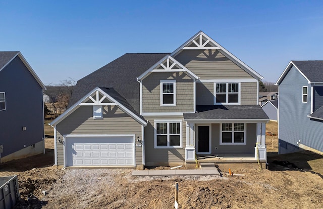 craftsman house with a garage and roof with shingles