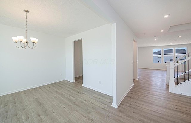 interior space with light wood-type flooring, a notable chandelier, recessed lighting, stairway, and baseboards