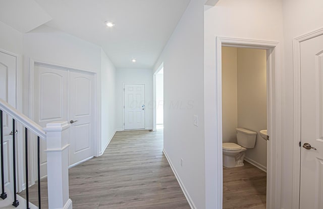 corridor featuring recessed lighting, baseboards, and light wood finished floors