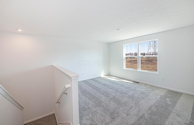 empty room featuring baseboards, carpet floors, and visible vents
