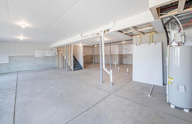 unfinished basement with stairs and water heater