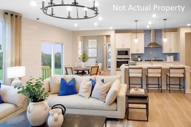 living room featuring an inviting chandelier and light hardwood / wood-style floors