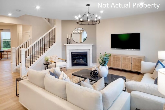 living room with an inviting chandelier and light wood-type flooring