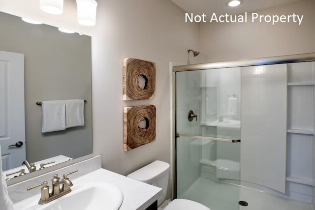 bathroom with vanity, toilet, and an enclosed shower