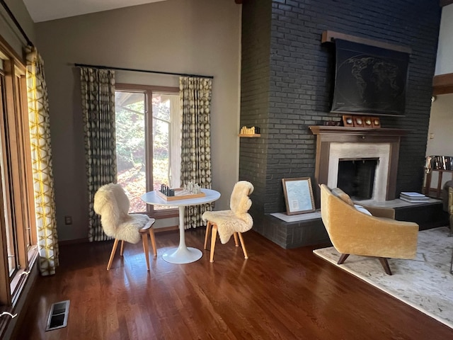 sitting room with lofted ceiling and dark wood-type flooring