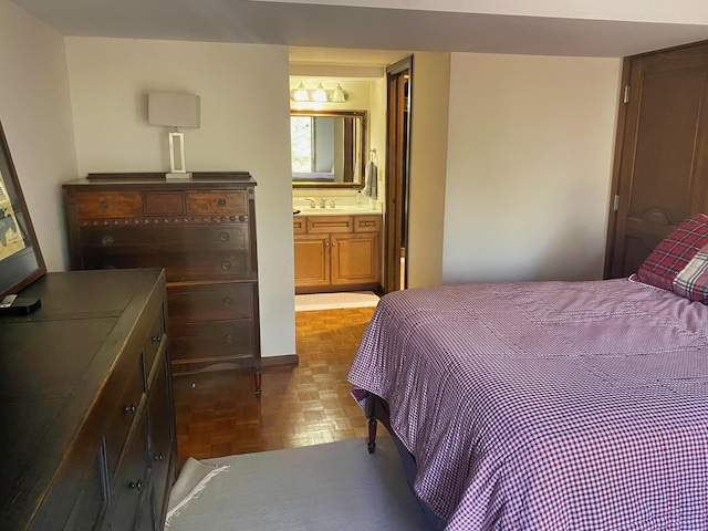 bedroom with parquet floors, sink, and ensuite bath