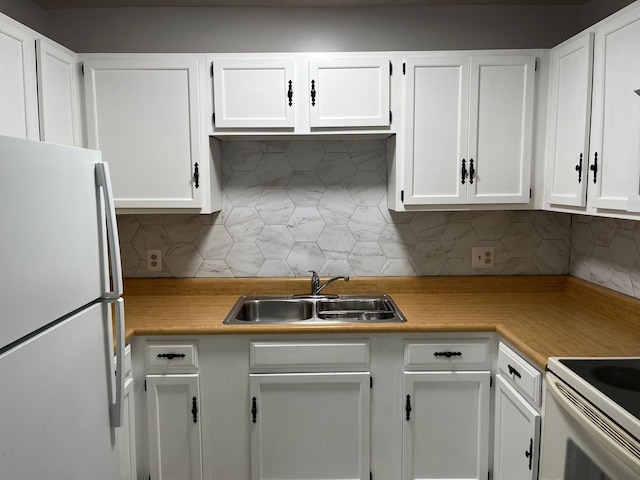 kitchen with white cabinets, white fridge, and sink