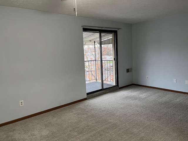 carpeted empty room with a textured ceiling