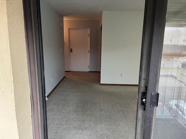 corridor featuring carpet floors and a textured ceiling