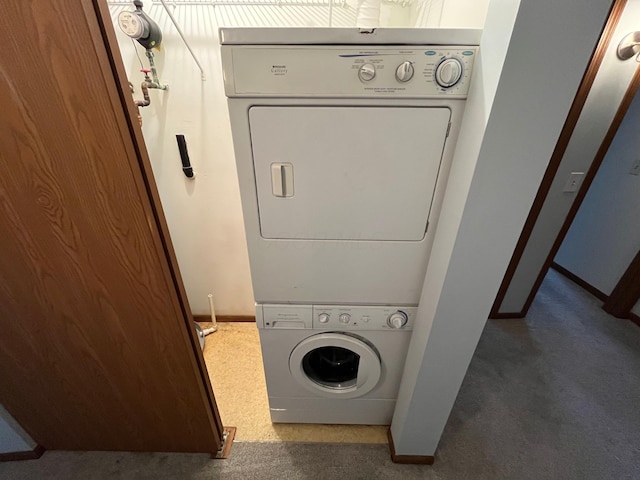 washroom with dark colored carpet and stacked washer and dryer