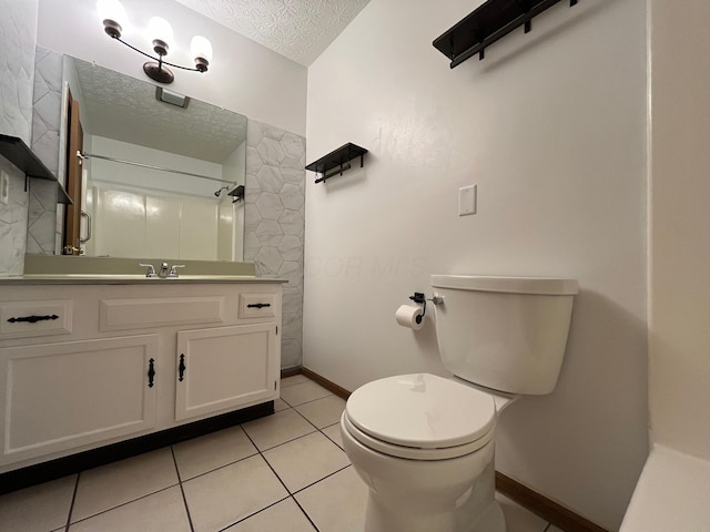 bathroom featuring tile patterned flooring, vanity, a textured ceiling, and toilet