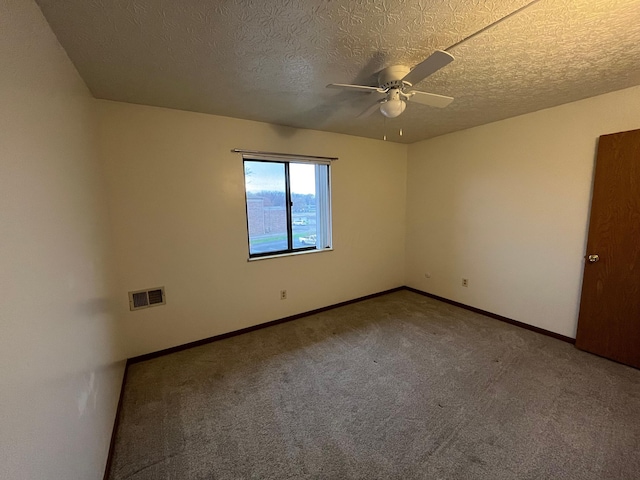 spare room featuring carpet flooring, ceiling fan, and a textured ceiling