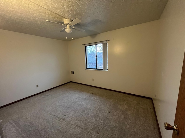 carpeted empty room featuring ceiling fan and a textured ceiling