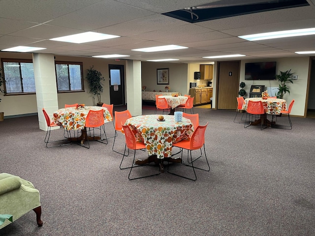 dining area featuring carpet flooring and a paneled ceiling