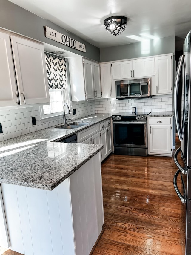 kitchen with white cabinets, sink, stainless steel appliances, and dark wood-type flooring