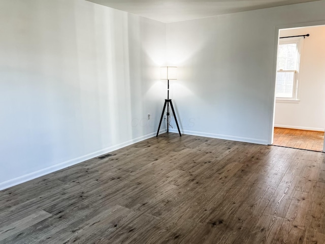 unfurnished room featuring dark wood-type flooring