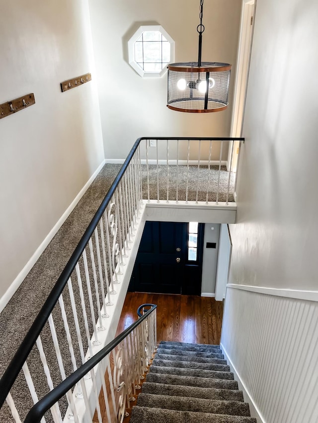 stairway featuring a healthy amount of sunlight and hardwood / wood-style flooring