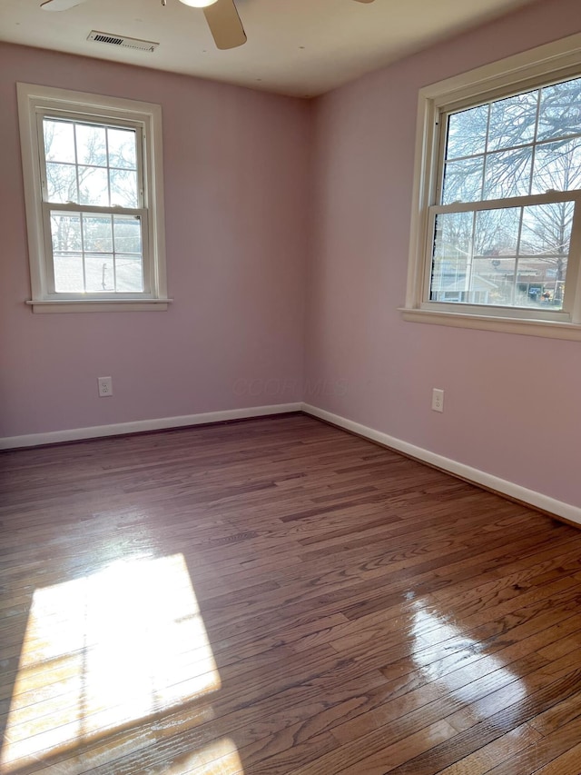 spare room with dark hardwood / wood-style floors and ceiling fan