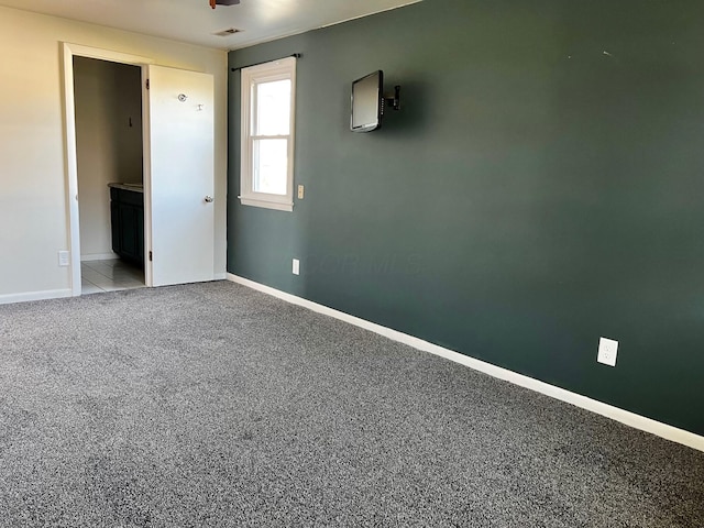 unfurnished bedroom with ensuite bath and light colored carpet