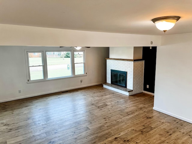 unfurnished living room featuring wood-type flooring and a fireplace