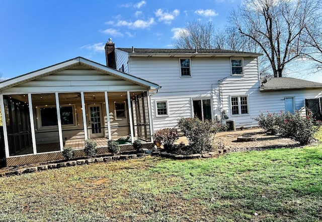 rear view of property featuring a sunroom and a yard