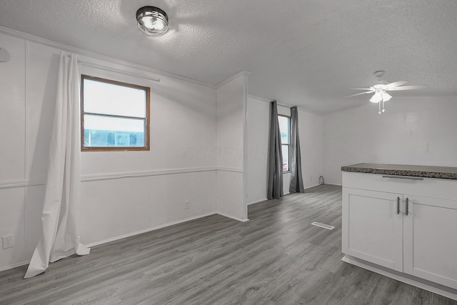 unfurnished room featuring ceiling fan, a textured ceiling, and light wood-type flooring