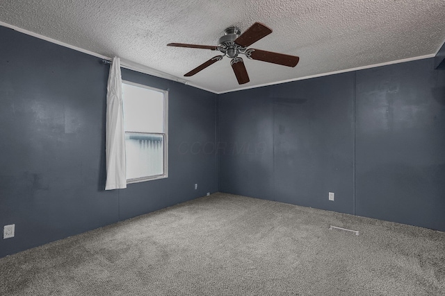 carpeted empty room featuring a textured ceiling, ceiling fan, and crown molding