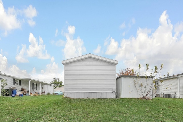 view of side of property with central AC unit and a lawn