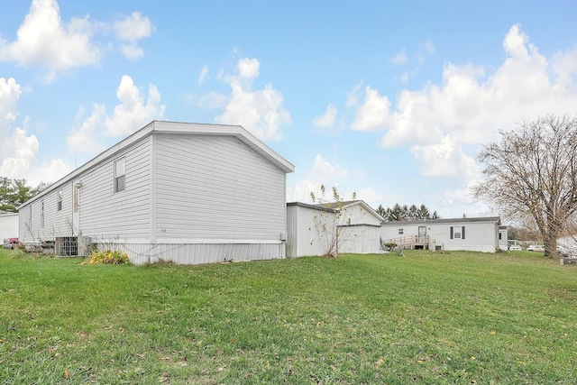 view of home's exterior featuring a lawn and central AC