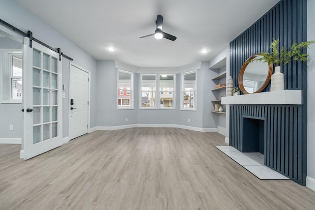 unfurnished living room featuring ceiling fan and hardwood / wood-style floors