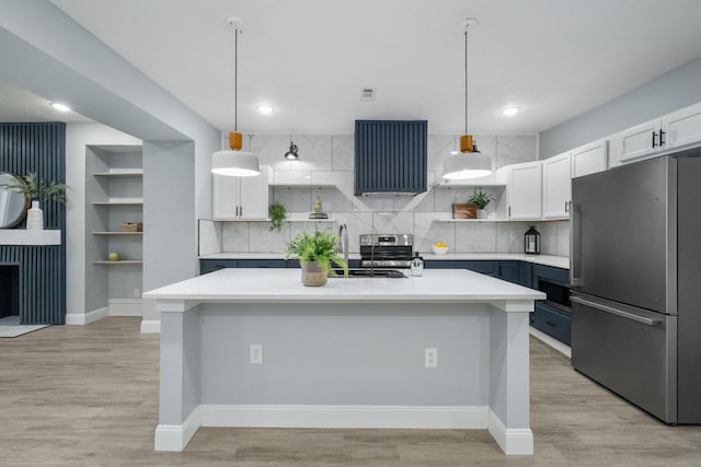 kitchen with pendant lighting, backsplash, white cabinetry, and stainless steel appliances