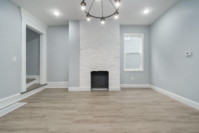 unfurnished living room with a stone fireplace and light hardwood / wood-style flooring