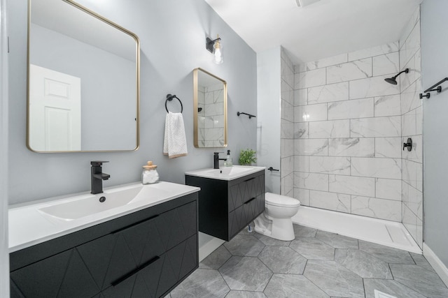 bathroom featuring tile patterned floors, vanity, toilet, and tiled shower