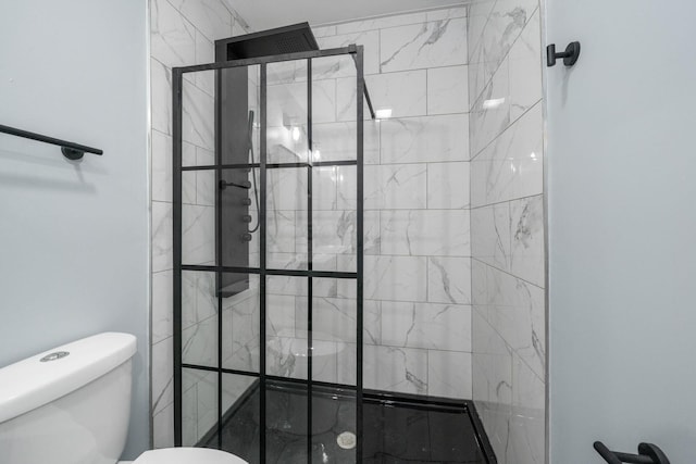 bathroom featuring a tile shower and toilet