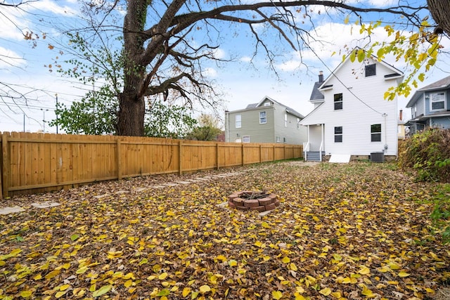 view of yard featuring central AC and an outdoor fire pit