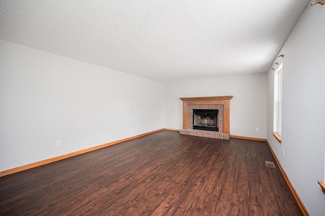 unfurnished living room with a fireplace, hardwood / wood-style floors, and a textured ceiling