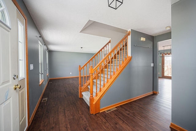 interior space with a textured ceiling and dark hardwood / wood-style floors