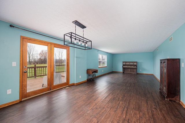 unfurnished living room featuring a textured ceiling, lofted ceiling, and dark wood-type flooring