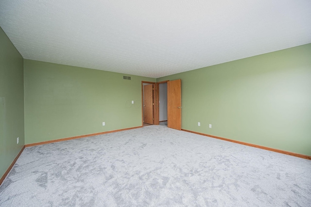 carpeted empty room with a textured ceiling