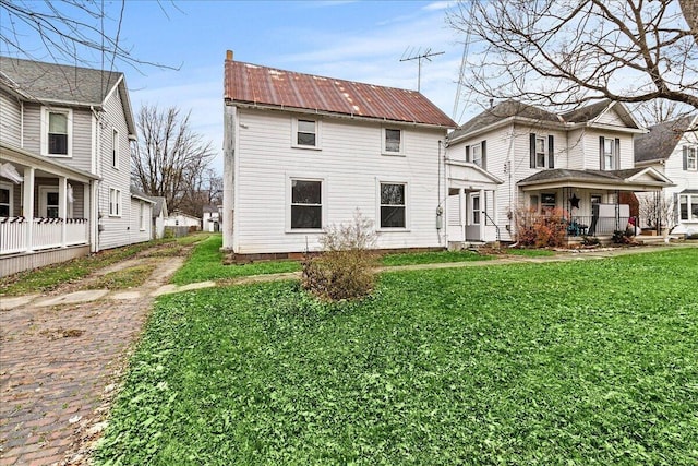 rear view of property with a porch and a yard