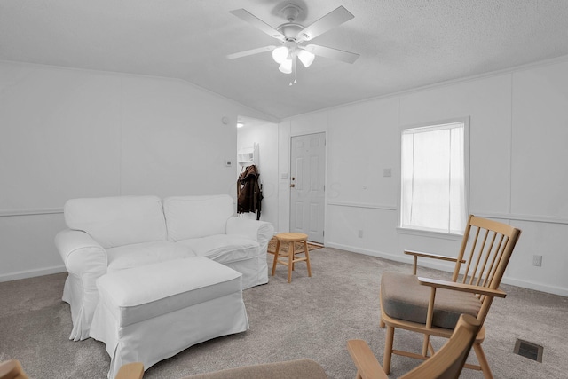 living room featuring carpet flooring, ceiling fan, a textured ceiling, and vaulted ceiling