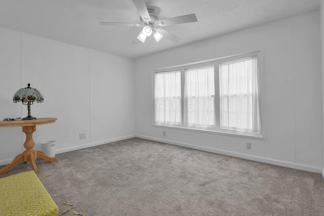 carpeted empty room featuring ceiling fan and a textured ceiling