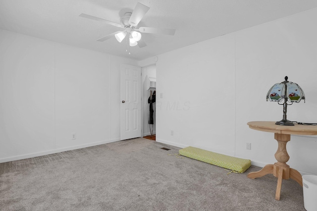 carpeted spare room featuring ceiling fan