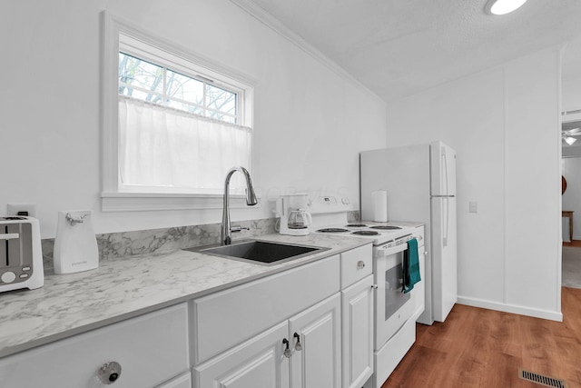 kitchen featuring white appliances, white cabinets, sink, ornamental molding, and dark hardwood / wood-style flooring