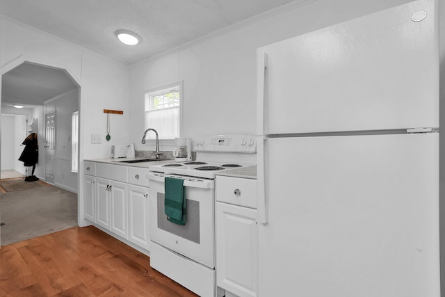 kitchen featuring white cabinetry, sink, light hardwood / wood-style flooring, a textured ceiling, and white appliances