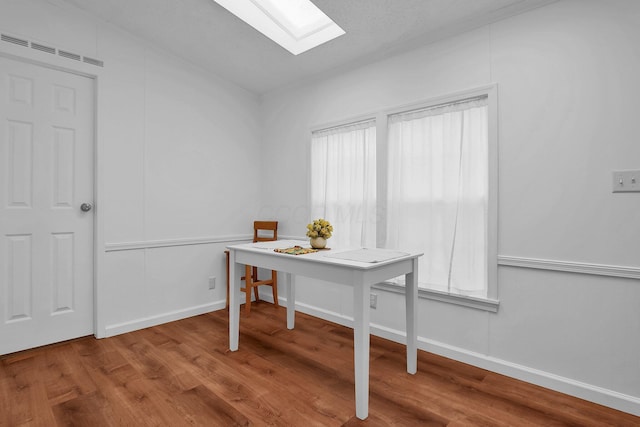 home office featuring a skylight and hardwood / wood-style floors